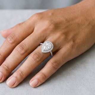 1 ct Pear Halo on Pavé Band Moissanite Ring in sterling silver, worn on hand