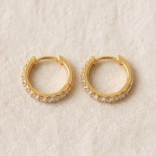 Slim shared prong moissanite huggie hoop earrings, macro detail of the shared prongs