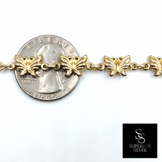 10K yellow gold butterfly link bracelet shown next to a quarter for size