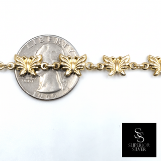 10K yellow gold butterfly link bracelet shown next to a quarter for size