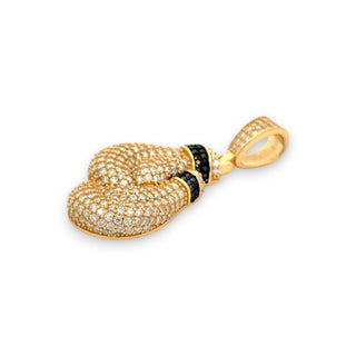 A gold pendant shaped like a boxing glove, heavily embellished with small clear stones and accented with a row of black stones, shown on a plain white background.