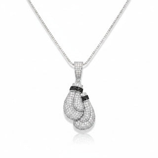A silver-tone boxers pendant necklace paved with clear stones, featuring black stone accents on the wrists, shown on a white background with a soft reflection.