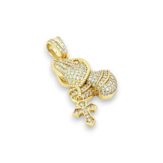 A gold pendant shaped like a praying hand holding a small cross, both heavily set with clear pavé stones, shown on a plain white background.