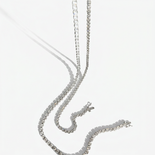 A silver-toned beaded chain necklace and matching bracelet with clear rhinestone-like beads, arranged on a clean white background.