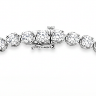 A close-up of a diamond tennis bracelet in a silver-colored setting, showing the clasp and several round-cut diamonds against a clean white background.