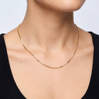 Superior Silver 16-inch 14K yellow gold box link chain necklace worn on a model, featuring a delicate 0.9mm width.
