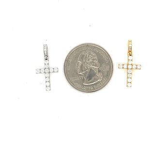 Dainty classic prong-set moissanite cross pendants in sterling silver and gold vermeil, shown beside a US quarter for scale