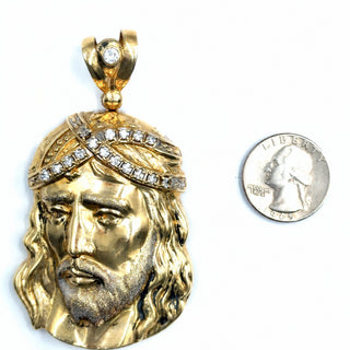 Superior Silver 10K yellow gold Jesus pendant featuring a CZ-encrusted crown of thorns, shown next to a US quarter.