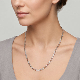 Superior Silver 20-inch curb link chain in polished 10K white gold worn around a woman's neck