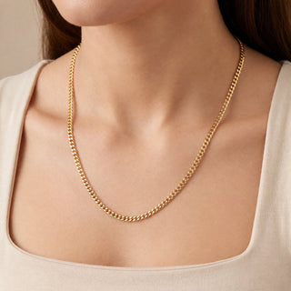 Superior Silver 18-inch 10K yellow gold curb link chain with a polished finish worn around a model's neck