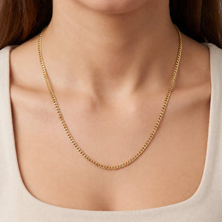 Superior Silver 10K yellow gold 1.9mm curb link chain worn around a woman's neck, featuring a polished finish.