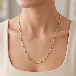 Superior Silver 22-inch curb link chain in solid 10K yellow gold worn around a model's neck
