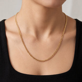 Superior Silver 22-inch 10K yellow gold curb link chain with a 2.9mm width worn around a person's neck.