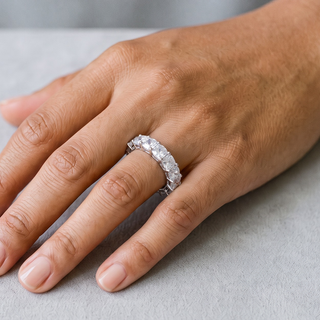 Cushion-Cut Shared-Prong Eternity Band Moissanite Ring in sterling silver, worn on hand