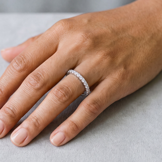 Dainty Round-Stone Full Eternity Band Moissanite Ring in sterling silver, worn on hand