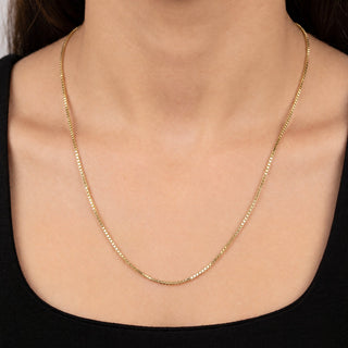 Superior Silver 24-inch 10K yellow gold box link chain with diamond-cut facets worn around a woman's neck.