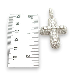 Domed Micro-Pavé Cross with Large Round Center Row Moissanite Pendant next to a ruler for size