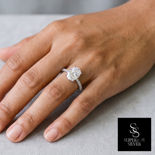Four-Prong Oval Solitaire on Pavé Band Moissanite Ring in sterling silver, worn on hand