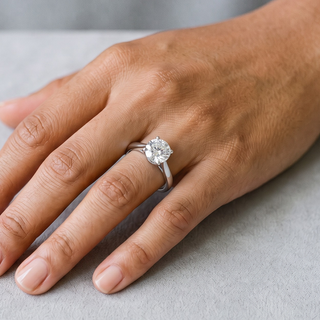 Four-Prong Round Cathedral Solitaire Moissanite Ring in sterling silver, worn on hand