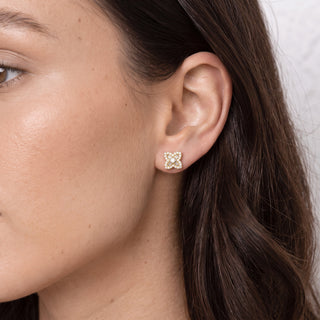 Model wearing gold vermeil baguette flower moissanite stud earrings