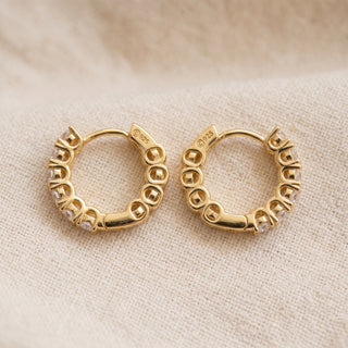 Gold vermeil 17mm eternity shared prong moissanite huggie hoop earrings, macro detail of the shared prong setting