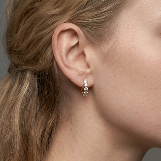 Gold vermeil 17mm eternity shared prong moissanite huggie hoop earrings shown on model