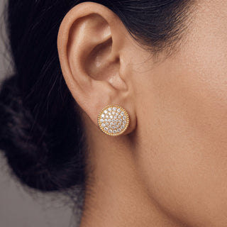 Model wearing gold vermeil round pavé disc moissanite stud earrings