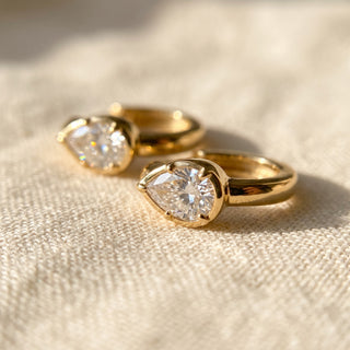 Close-up of the gold vermeil pear huggie showing the polished hoop and hinged snap closure