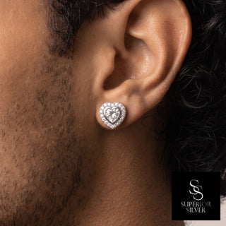 Heart cut bezel halo moissanite stud earrings in sterling silver, worn on model