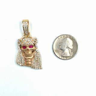 Superior Silver 14K yellow gold Jesus pendant featuring natural diamonds and genuine ruby eyes next to a US quarter.