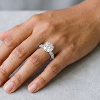 Large Four-Prong Round Solitaire on Three-Row Pavé Band Moissanite Ring in sterling silver, worn on hand