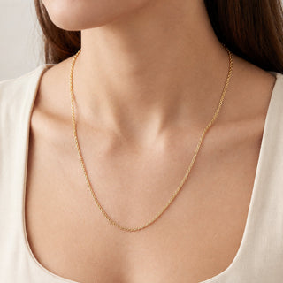 Superior Silver 22-inch 1.6mm solid 10K yellow gold cable link chain worn around a woman's neck.