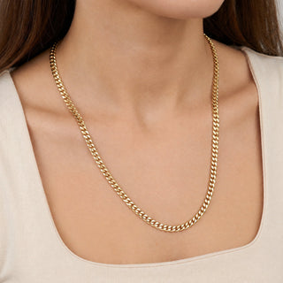 Superior Silver 18-inch 3.5mm Miami Cuban link chain in solid 10K yellow gold worn around a woman's neck