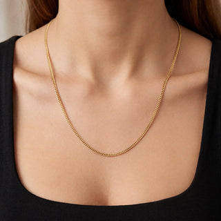 Superior Silver 10K yellow gold micro curb link chain worn on a neck, featuring a delicate 1.0mm width and 22-inch length