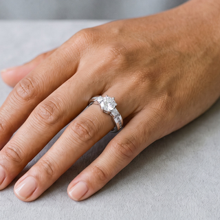 Round Three-Stone with Channel-Set Shoulders Moissanite Ring in sterling silver, worn on hand