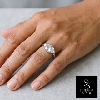 Sideways Marquise Bezel Polished Band Moissanite Ring in sterling silver, worn on hand