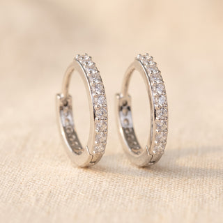 Close-up of the sterling silver slim pave huggie showing bead-set stones across the front arc