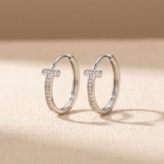 Sterling silver 18mm slim pave T bar moissanite huggie hoop earrings, macro detail of the T bar