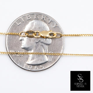 Superior Silver 10K yellow gold 0.9mm box link chain with lobster clasp, shown against a US quarter for scale.