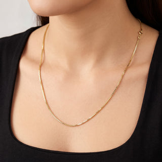 Superior Silver 20-inch 10K yellow gold diamond-cut box link chain worn on a model against a black top
