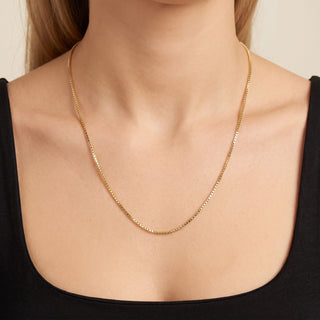 Superior Silver 10K yellow gold diamond-cut box link chain necklace worn on a model against a black top