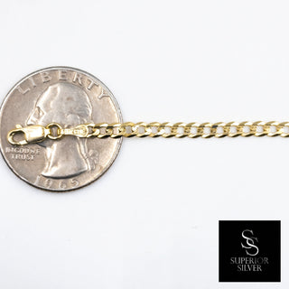 Superior Silver 10K yellow gold 3mm curb link bracelet with a lobster clasp shown next to a US quarter for scale.