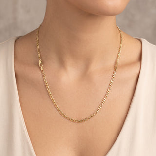 Superior Silver 20-inch 10K yellow gold figaro link chain with a lobster clasp worn around a model's neck