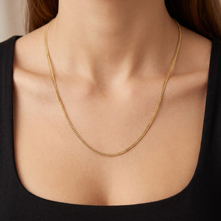 Superior Silver 10K yellow gold micro curb link chain worn on a neck, featuring a delicate 1.0mm width and 22-inch length