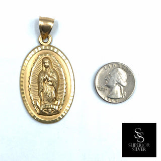 Superior Silver 10K yellow gold Mother Mary oval pendant with diamond-cut detailing next to a US quarter for scale.
