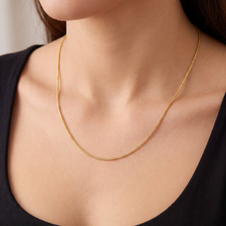 Superior Silver 18-inch 10K yellow gold wheat chain necklace with a delicate 1.0mm braided weave worn on a model.