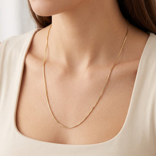 Superior Silver 22-inch 1.0mm solid 10K yellow gold box chain necklace worn on a person