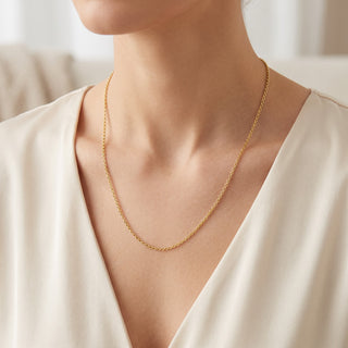Superior Silver 18-inch 10K yellow gold cable link chain worn on a model, featuring a 1.55mm width and spring clasp.