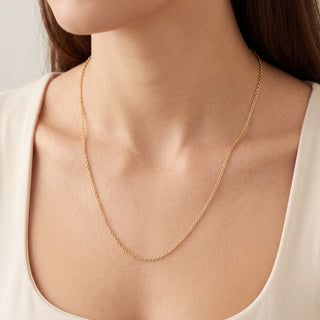 Superior Silver 22-inch 1.6mm solid 10K yellow gold cable link chain worn around a woman's neck.