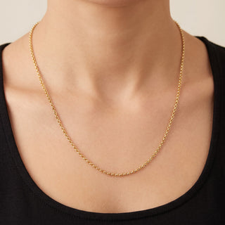 Superior Silver 24-inch 1.6mm solid 10K yellow gold cable link chain worn around a person's neck